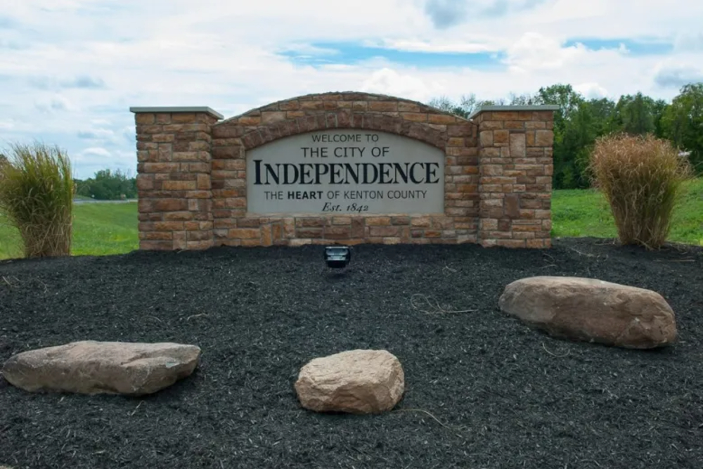independence kentucky | Davis Landscape Design & Installation Stone entry sign that reads 'Welcome to the City of Independence, The Heart of Kenton County' with rocks and shrubs around it.