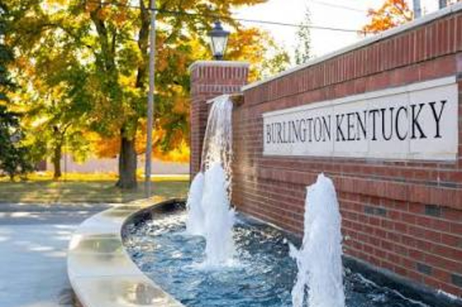 Burlington Ky 1 | Davis Landscape Design & Installation Brick sign reading Burlington Kentucky with a curved water fountain feature and fall trees in the background.